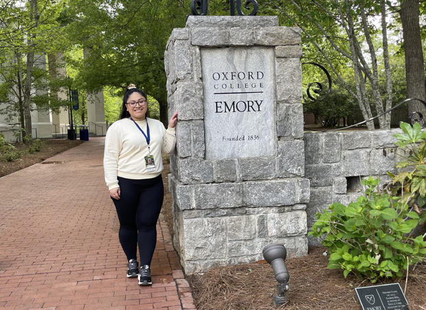 Ashley Rodriguez standing by a sign for Oxford College of Emory University 