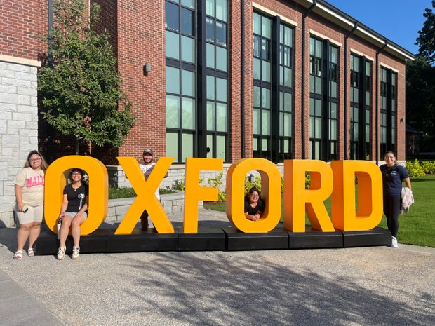 Rodriguez family standing by a sign for Oxford College