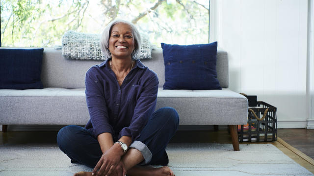 Portrait of senior woman sitting on floor at home 