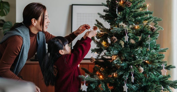 mother and daughter decorating Christmas tree