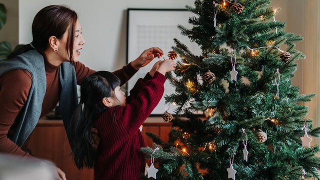 mother and daughter decorating Christmas tree