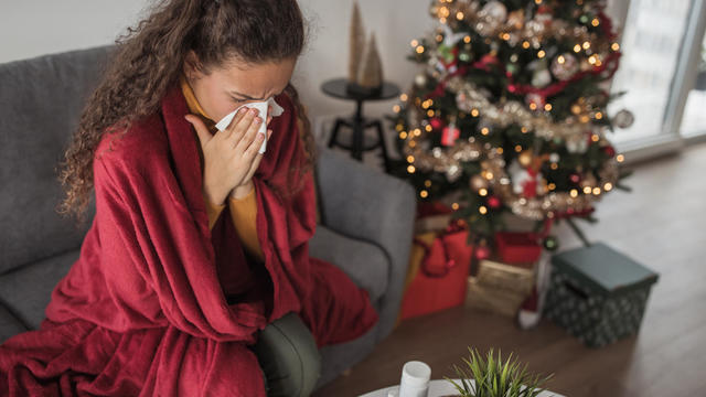 Girl sitting at home during winter holidays with a flu virus 
