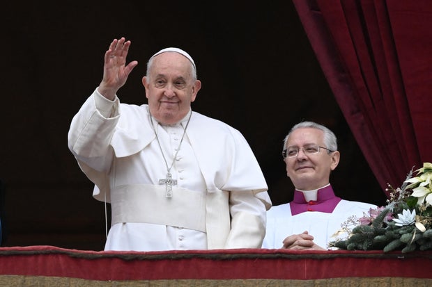 Pope Francis waves from the balcony of St. Peter's basilica on Christmas