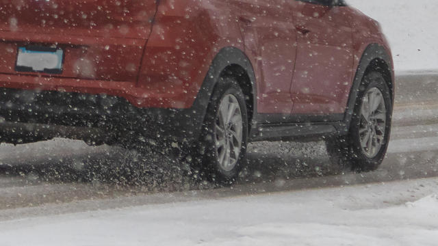 Red Car Driving on an Icy Snowy Road 