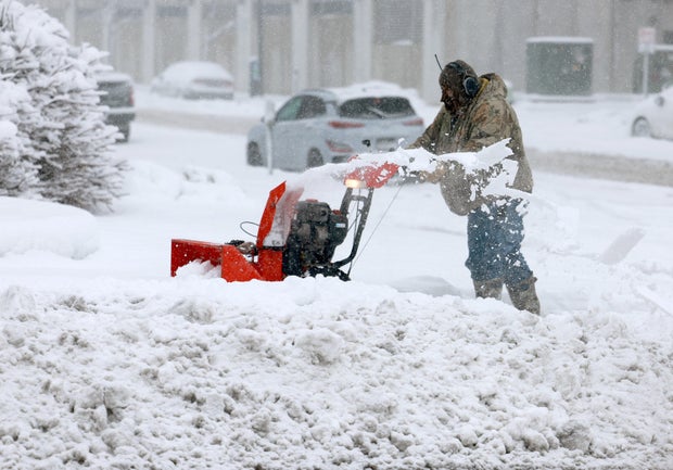A person uses a snowblower to clear a sidewalk in Des Moines, Iowa, as a snowstorm dumps several inches of snow on the area Jan. 9, 2024.
