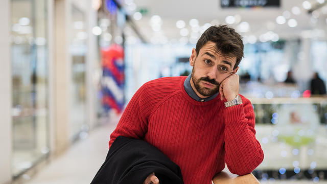 Young man feeling tired from shopping in a mall 