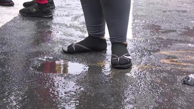 An asylum seeker wears socks with flip-flops while standing outside in cold winter weather. 