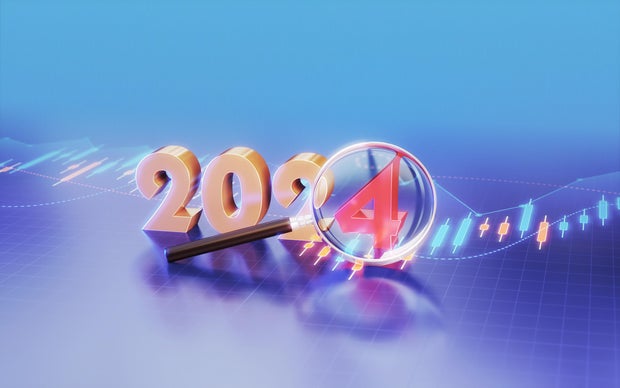 New Year 2024 sitting at a table with business, financial and technical data marked with a magnifying glass