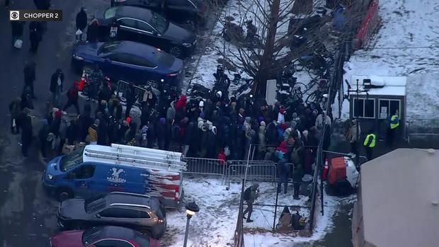 An aerial view of a crowd outside an asylum seeker shelter on Wards Island. 