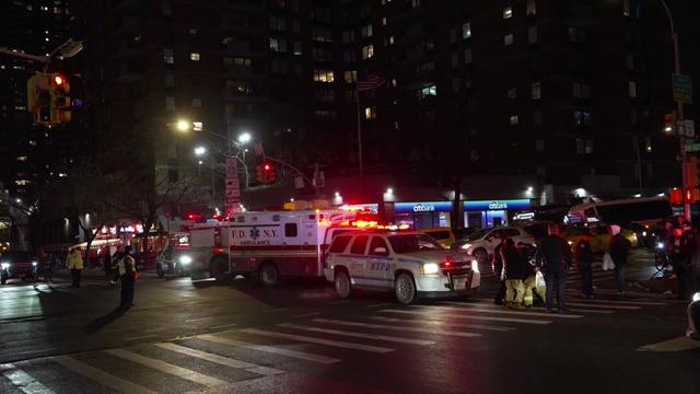 An ambulance and an NYPD vehicle in the intersection at 42nd Street and Ninth Avenue. 