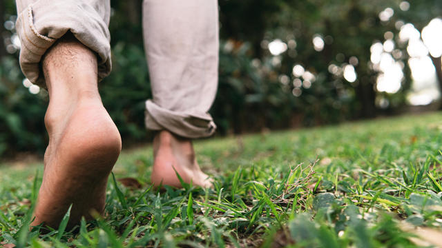 Bare feet of a man walking on the grass 