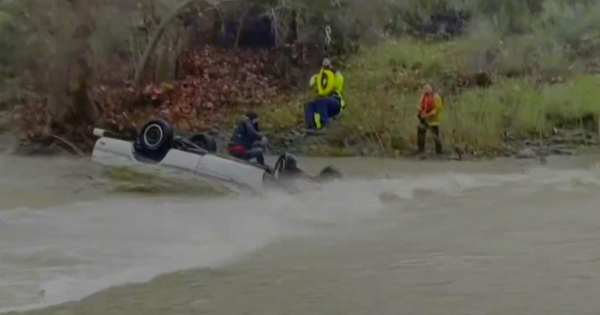 Crews rescue woman stranded on top of her car in the middle of a ...