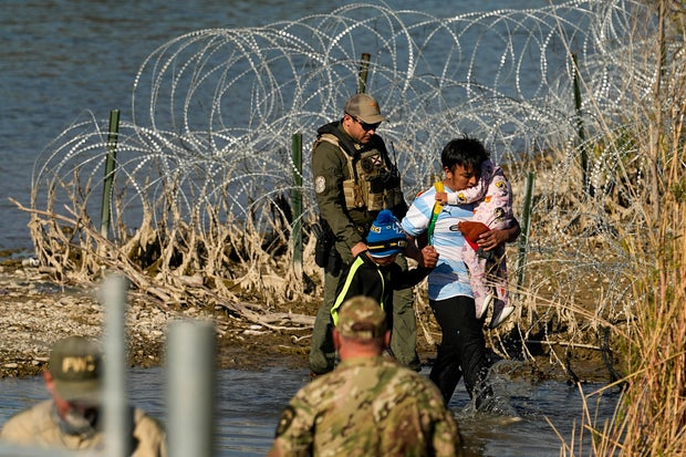 Migrants are taken into custody by officials at the U.S.-Mexico border on Wednesday, Jan. 3, 2024, in Eagle Pass, Texas.