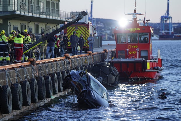 Rescue personnel retrieve a Tesla car from the water after it plunged into the Oslofjord on Feb. 1, 2024, in Oslo