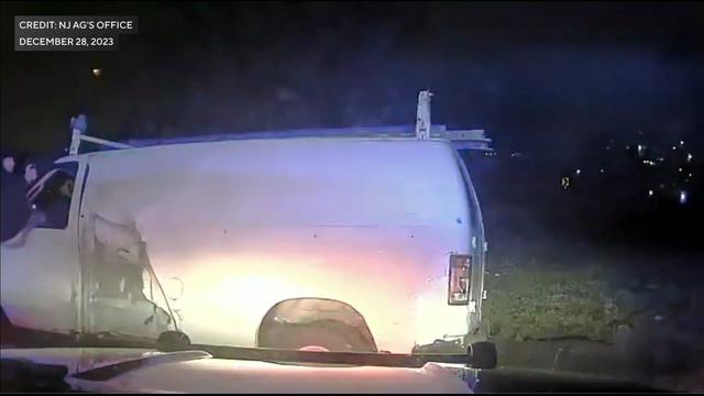Dash cam video shows a man sitting in the driver's side window of a white van holding what appears to be a gun. 