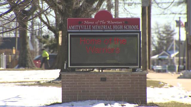 A sign outside Amityville Memorial High School reading, "Home of the Warriors." 