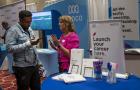 Minneapolis, Minnesota. People of color Career Fair. A networking and hiring event for professionals of color. A person checks out career opportunities at the Midco booth. 
