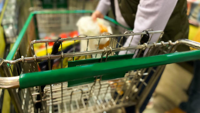 dad unloading groceries at checkout counter for purchase 