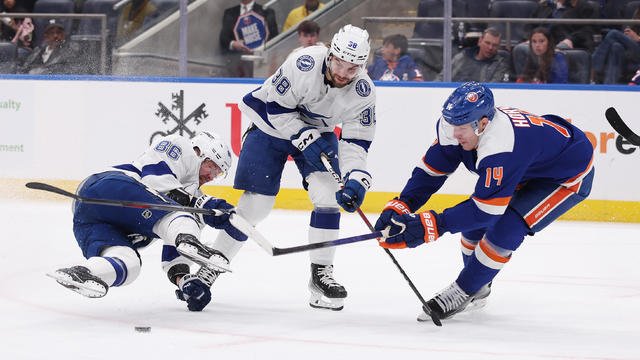 Nikita Kucherov #86, and Brandon Hagel #38 of the Tampa Bay Lightning in action against Bo Horvat #14 of the New York Islanders during their game at UBS Arena on February 24, 2024 in Elmont, New York. 