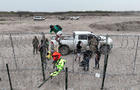 An aerial view shows a group of migrants climbing up wire fences in Eagle Pass, Texas, on Feb. 28, 2024. 