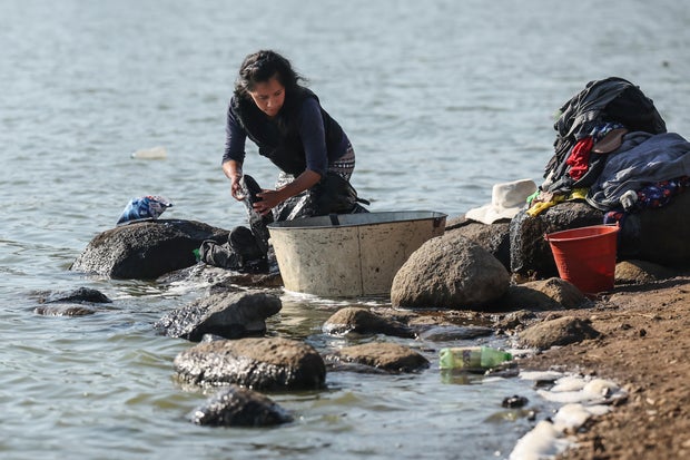 Women wash clothes on the dry banks of the Villa Victoria dam, which is at 30.5 percent of its capacity on February 28, 2024 in Villa Victoria, Mexico