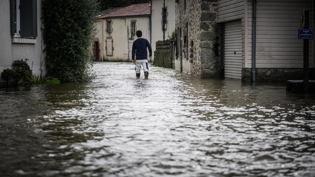 A man walks down a flooded street in France 