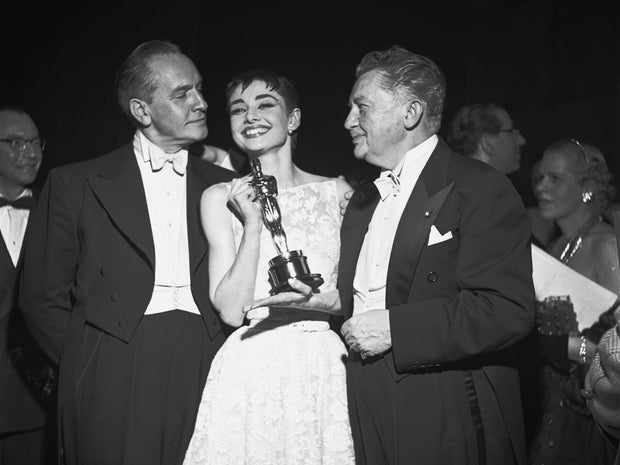 Audrey Hepburn smiles with her best actress award for her performance in