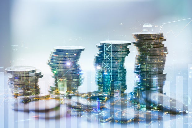 Double exposure of city with graph and stack of coins for finance and business concept