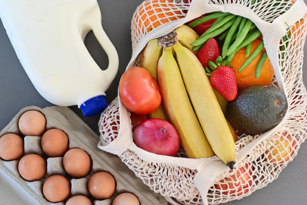 Shopping bag full of fresh vegetables and fruits with milk and eggs 