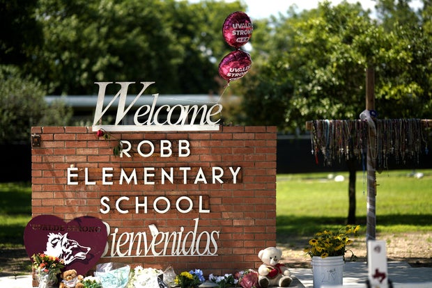 Flores e brinquedos são colocados do lado de fora da antiga Escola Primária Robb em Uvalde, Texas, em 24 de maio de 2023.