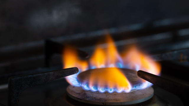 Closeups of a natural gas stove flame on dark background 
