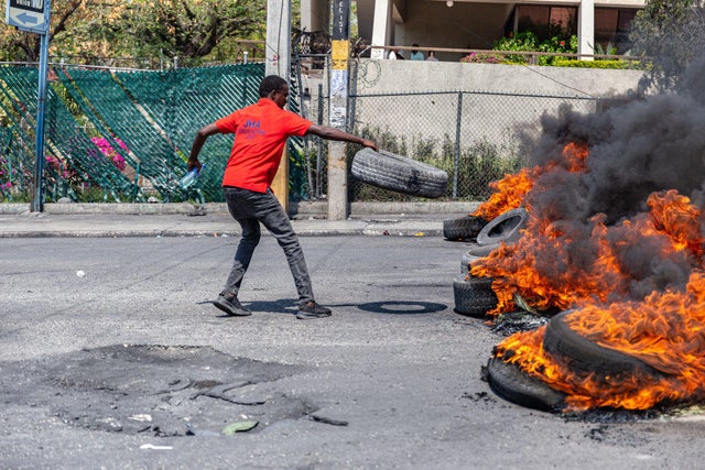 A man sets a tire on fire during a demonstration in Port-au-Prince, Haiti, on March 12, 2024. 
