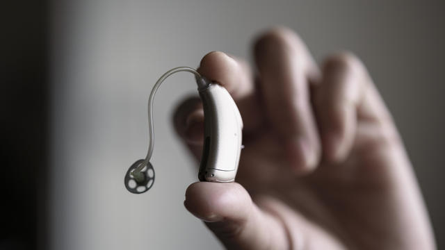 Hand holding hearing aid 