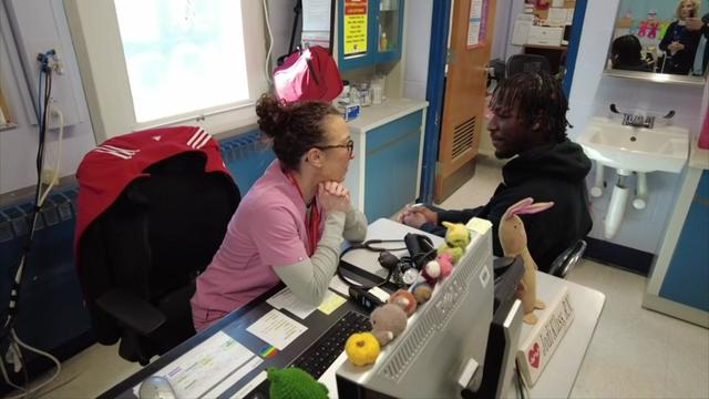 Quintin Folkes sits in the school nurse's office with nurse Jodi Klass. 