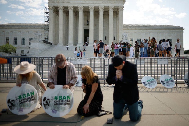 Anti-abortion rights activists pray in front of the Supreme Court on April 21, 2023.