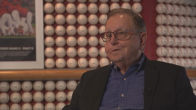 Dan Baker speaks, in front of a wall of baseballs at Citizens Bank Park 