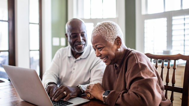Senior couple using laptop at home 