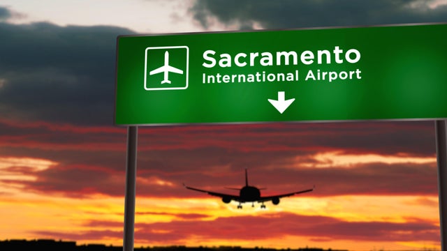 Plane landing in Sacramento California, USA airport with signboard 