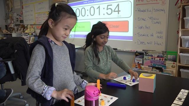 Two girls in third grade participate in a science class activity. 