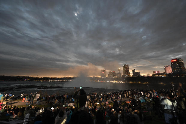 The sky darkens as people watch during totality of the total solar eclipse at Niagara Falls State Park in Niagara Falls, New York, on April 8, 2024. 