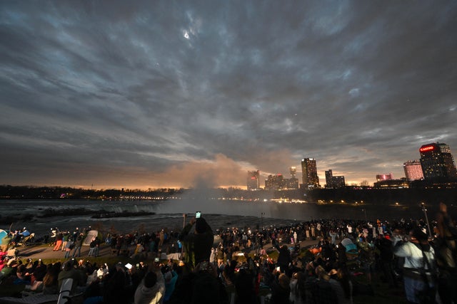 The sky darkens as people watch during totality of the total solar eclipse at Niagara Falls State Park in Niagara Falls, New York, on April 8, 2024. 