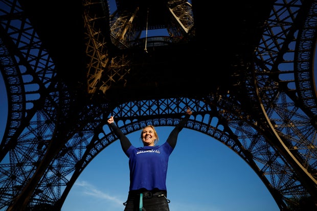 Athlete Anouk Garnier celebrates the world record for rope climbing on the Eiffel Tower in Paris