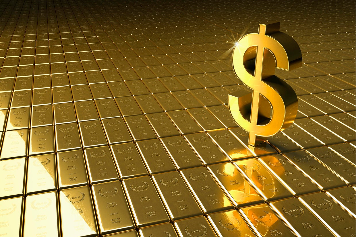 High angle view of gold bars and dollar symbol 
