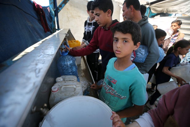 Palestinians wait in front of water dispensers in Rafah, Gaza, to meet their daily water needs April 17, 2024.