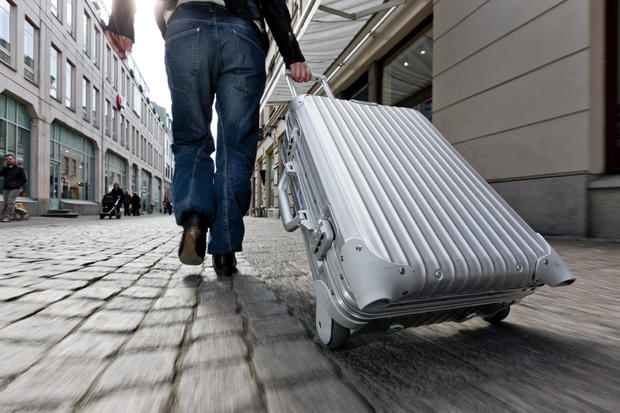 Woman pulling aluminum luggage 