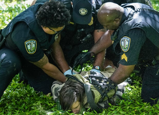 Police officers detain a demonstrator during a protest against the war in Gaza at Emory University on April 25, 2024, in Atlanta, Georgia.