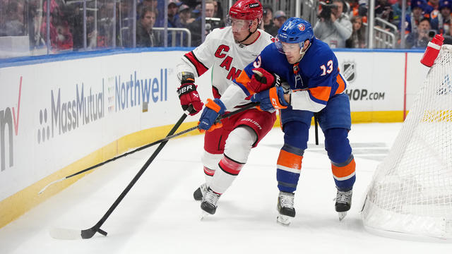 Mathew Barzal #13 of the New York Islanders and Dmitry Orlov #7 of the Carolina Hurricanes battle for the puck in Game Three of the First Round of the 2024 Stanley Cup Playoffs at UBS Arena on April 25, 2024 in Elmont, New York. 