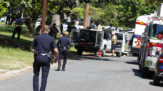 Officers with the Charlotte-Mecklenburg Police Department work in the neighborhood where a shooting took place in Charlotte, North Carolina, April 29, 2024. 