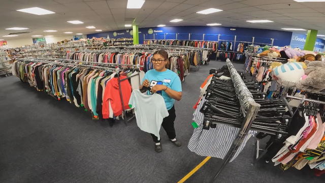 An employee stands in the middle of the Goodwill store as staff prepare to reopen 