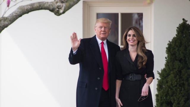 President Donald Trump waves beside White House communications director Hope Hicks as he walks from the Oval Office on Thursday, March 29, 2018. 